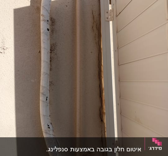 צינור עטוף בסרט דביק ליד קיר עם סדק